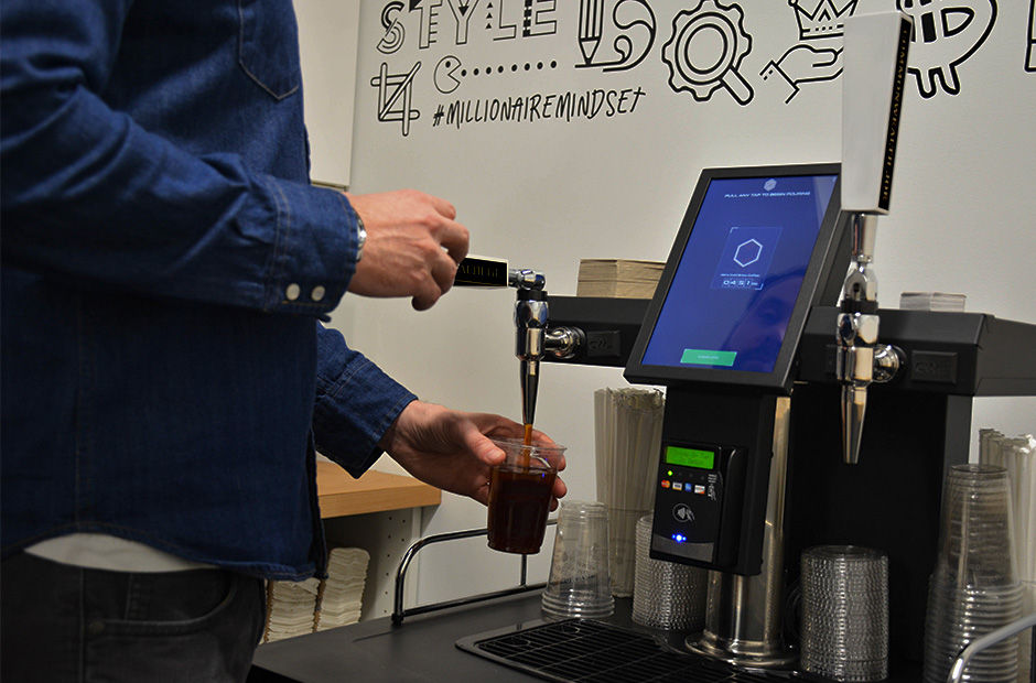 KVM Automated Coffee in use - customer pouring craft cold brew from self-service tap system